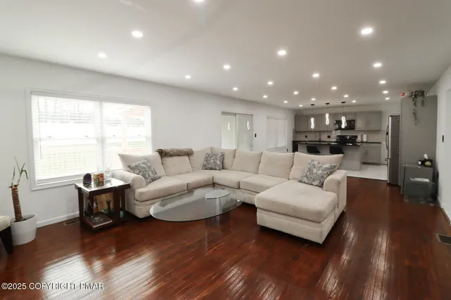 a living room with furniture and a wooden floor