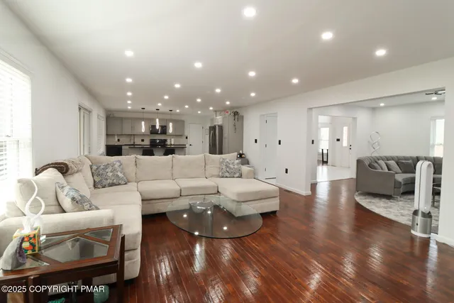 a living room with furniture and a wooden floor