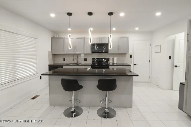 a living room with furniture and a refrigerator