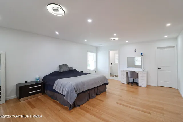 a large bedroom with a bed and a large window