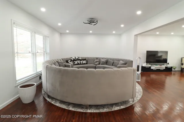 a living room with furniture and a hard wood floor