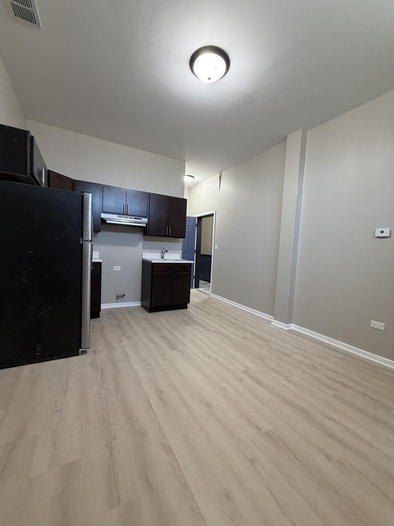 24 North Pulaski Road, Unit 1F Chicago, IL 60624 - Photo 4 of 10 a view of empty room with kitchen and window