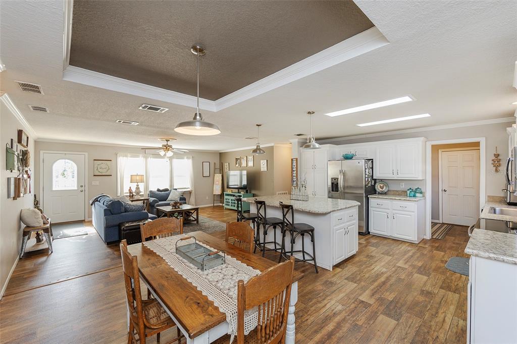 2100 East Kicklighter Road Lake Helen, FL 32744 - Photo 11 of 61 a living room with furniture a dining table wooden floor and a fireplace