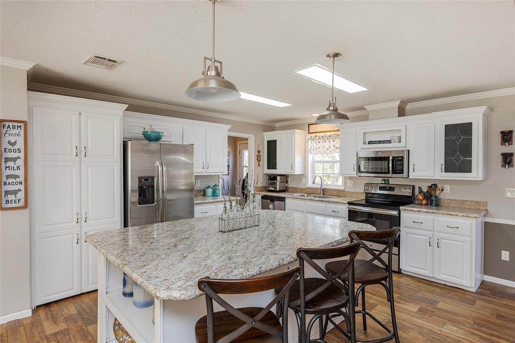 2100 East Kicklighter Road Lake Helen, FL 32744 - Photo 12 of 61 a kitchen with stainless steel appliances granite countertop a kitchen island hardwood floor and a sink