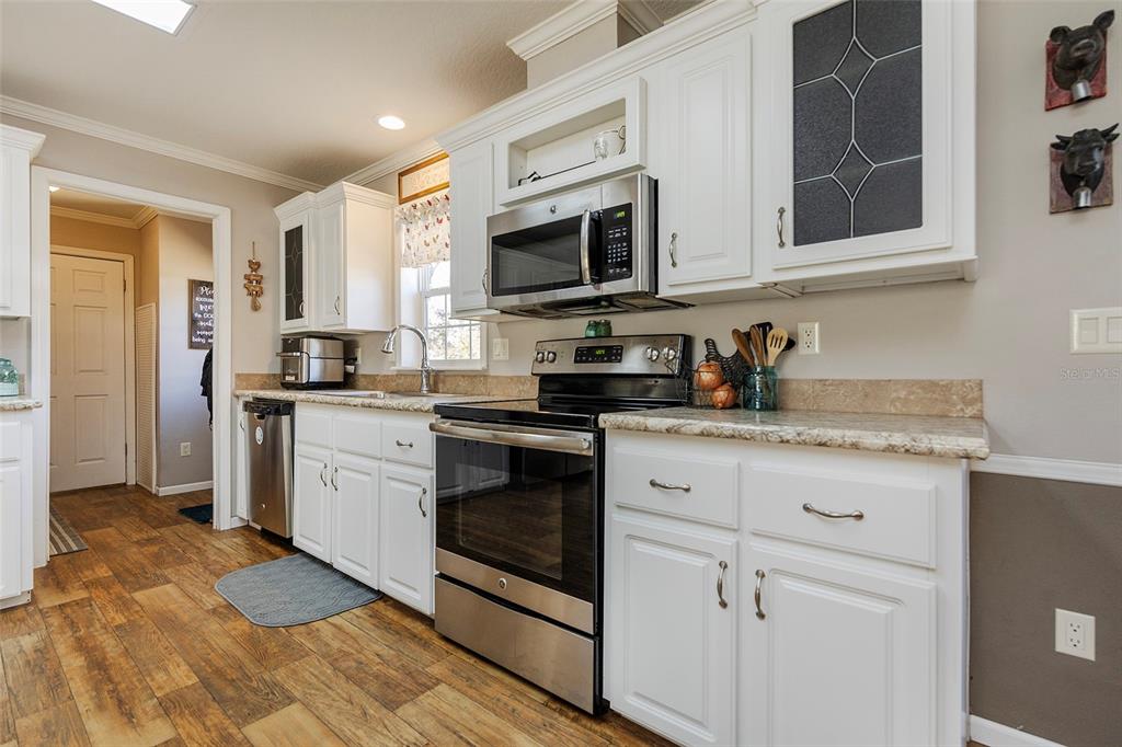 2100 East Kicklighter Road Lake Helen, FL 32744 - Photo 14 of 61 a kitchen with stainless steel appliances granite countertop a sink a stove a microwave and cabinets