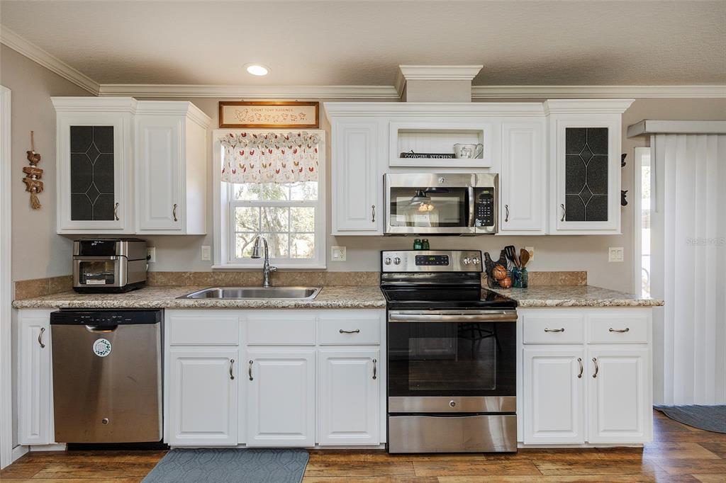 2100 East Kicklighter Road Lake Helen, FL 32744 - Photo 15 of 61 a kitchen with stainless steel appliances granite countertop a stove and a sink