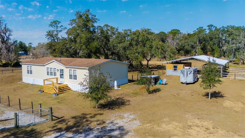2100 East Kicklighter Road Lake Helen, FL 32744 - Photo 2 of 61 an aerial view of a house with yard and trees in the background