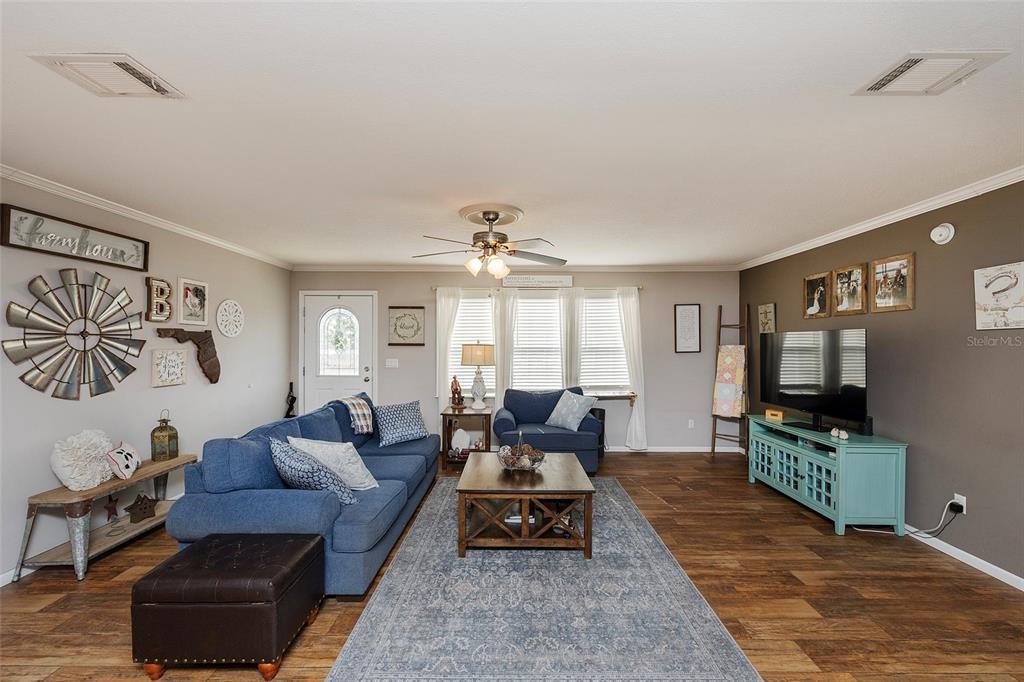 2100 East Kicklighter Road Lake Helen, FL 32744 - Photo 21 of 61 a living room with furniture a flat screen tv and a large window