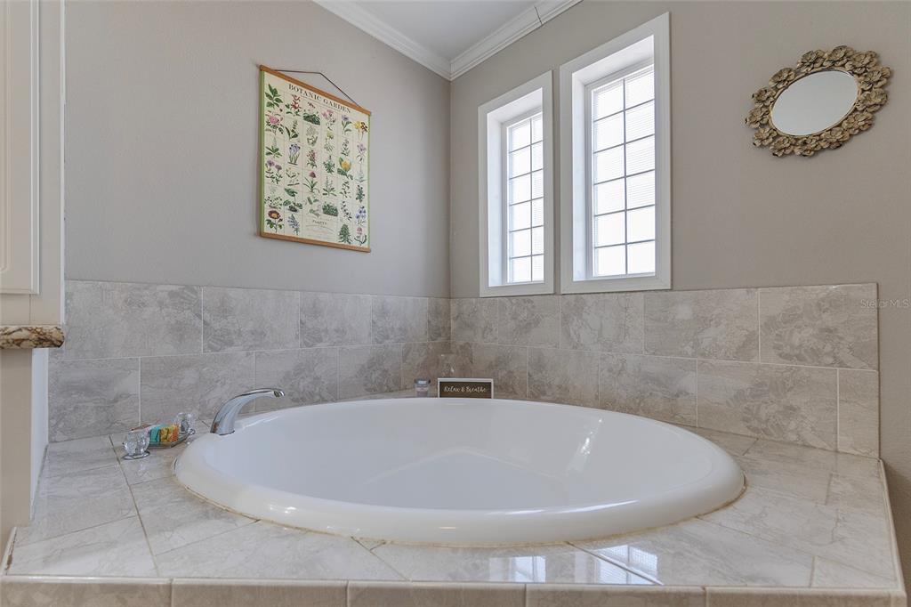 2100 East Kicklighter Road Lake Helen, FL 32744 - Photo 28 of 61 a white bath tub sitting in a bathroom next to a window