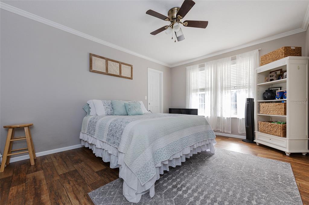 2100 East Kicklighter Road Lake Helen, FL 32744 - Photo 36 of 61 a spacious bedroom with a bed and a chandelier