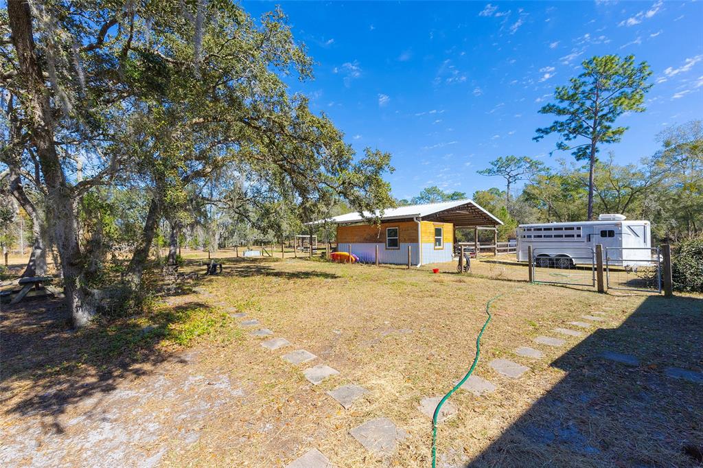 2100 East Kicklighter Road Lake Helen, FL 32744 - Photo 39 of 61 a yellow house with trees in front of it
