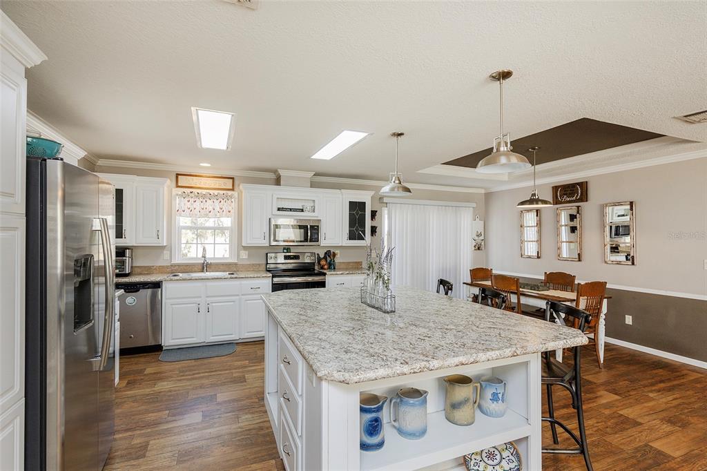 2100 East Kicklighter Road Lake Helen, FL 32744 - Photo 5 of 61 a kitchen with stainless steel appliances granite countertop a stove and refrigerator