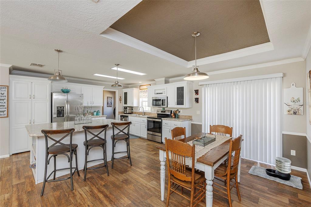 2100 East Kicklighter Road Lake Helen, FL 32744 - Photo 10 of 61 a dining area with stainless steel appliances kitchen island granite countertop a dining table chairs and granite counter tops