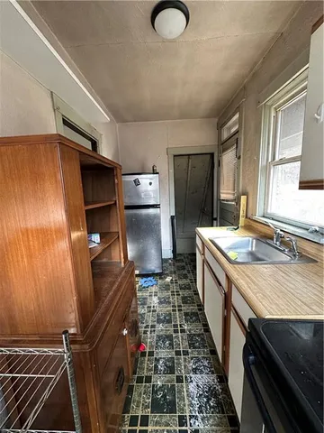 a kitchen with sink refrigerator and stove