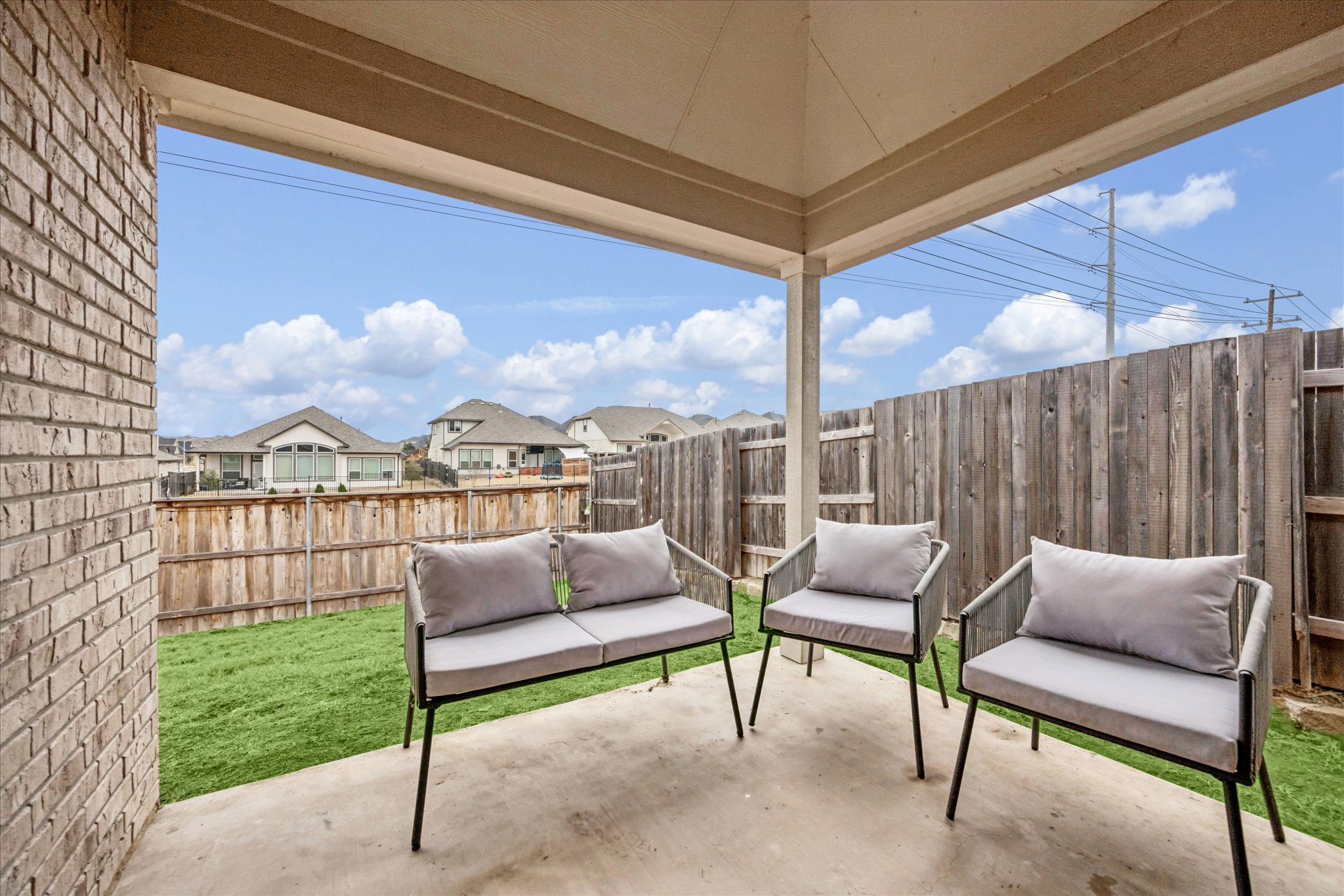 540 Sugar Cane Buda, TX 78610 - Photo 11 of 11 Fenced backyard featuring a patio, a residential view, and outdoor seating