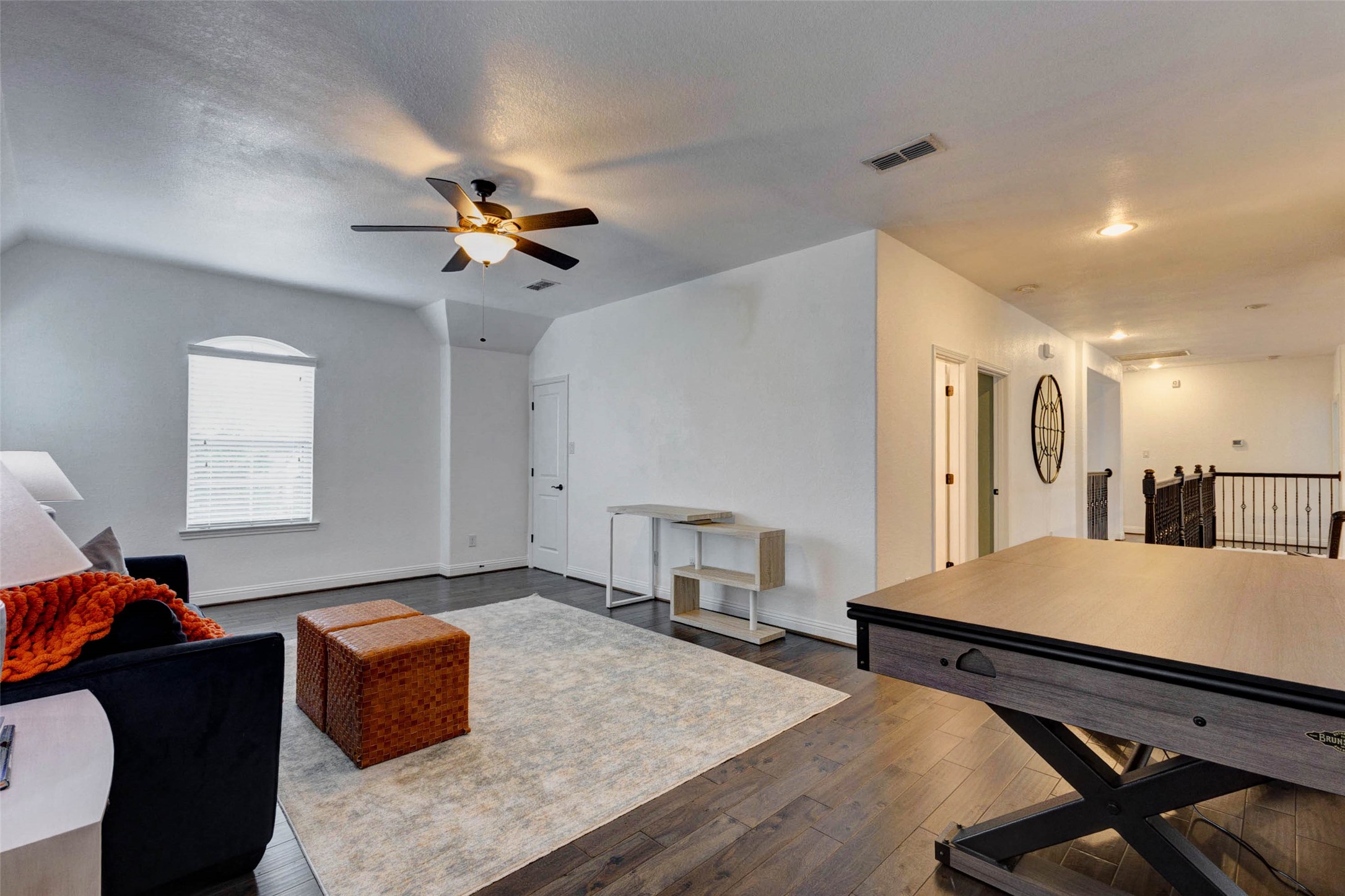 29903 Spring Side Court Fulshear, TX 77406 - Photo 33 of 50 Upstairs, you will find this spacious game room featuring hardwood floors, a ceiling fan, a convenient storage closet, and a large window that fills the space with beautiful natural light.