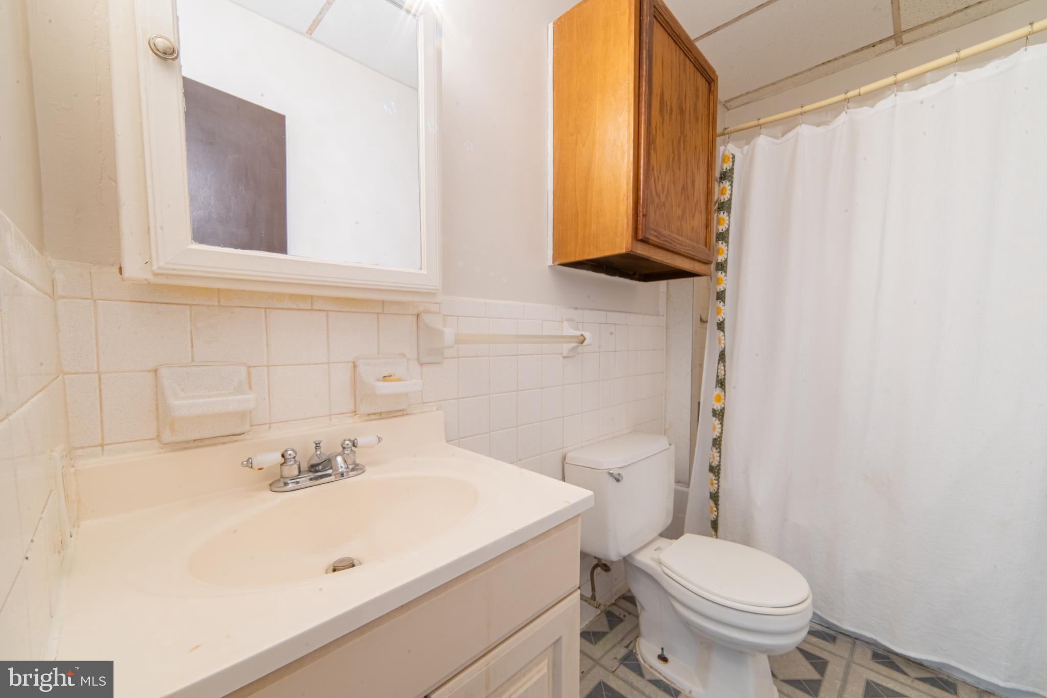 125 West Commerce Street, Unit 2 Bridgeton, NJ 08302 - Photo 3 of 7 a bathroom with a sink a toilet and mirror