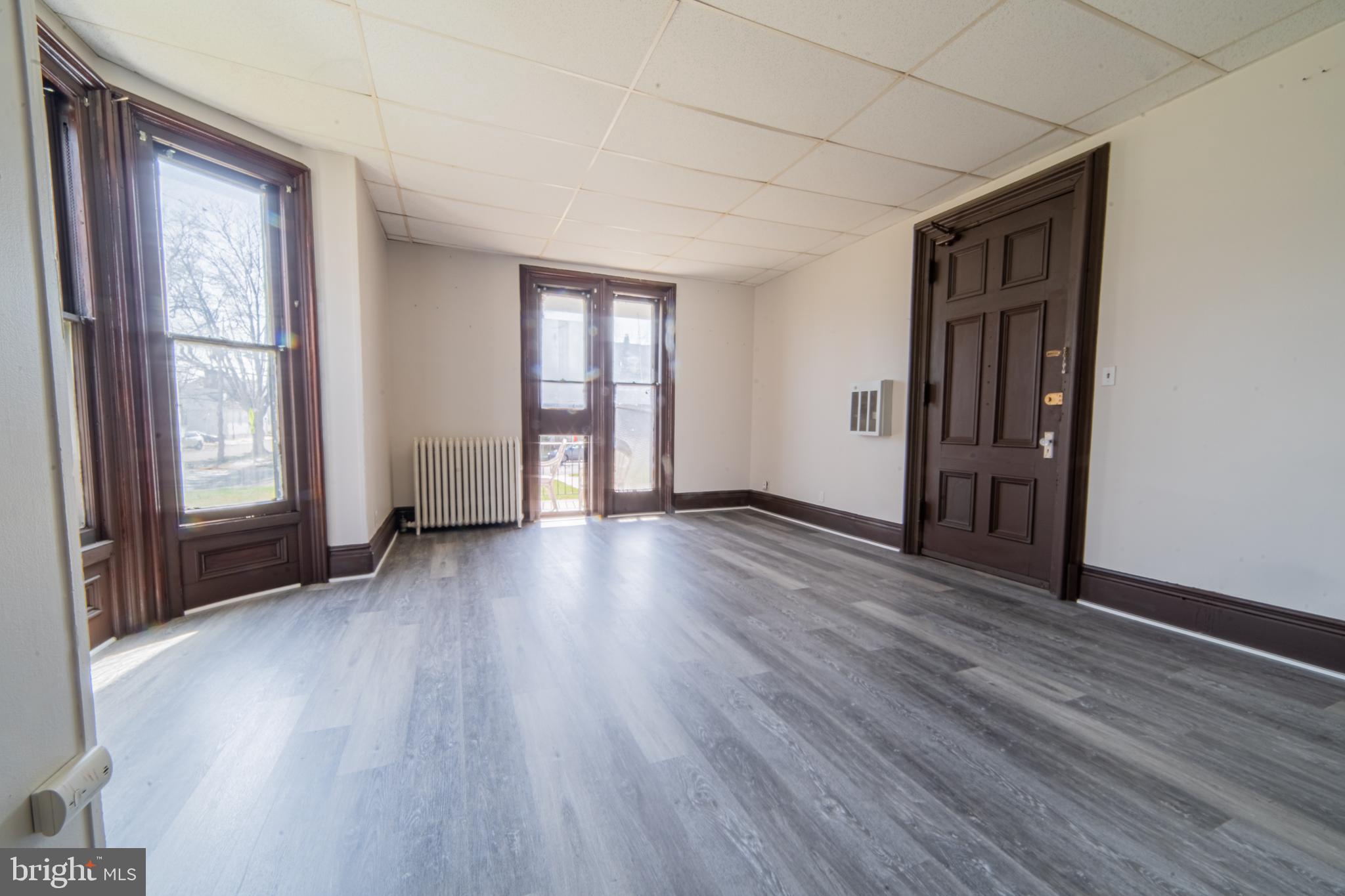 125 West Commerce Street, Unit 2 Bridgeton, NJ 08302 - Photo 5 of 7 an empty room with wooden floor and windows