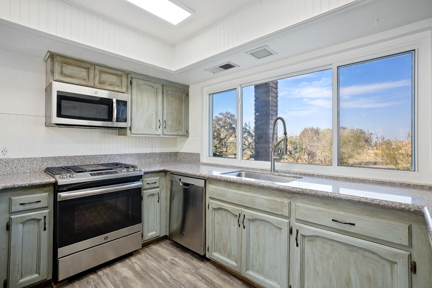 43036 Jacalitos Creek Road Coalinga, CA 93210 - Photo 17 of 85 a kitchen with stainless steel appliances granite countertop white cabinets and a stove top oven