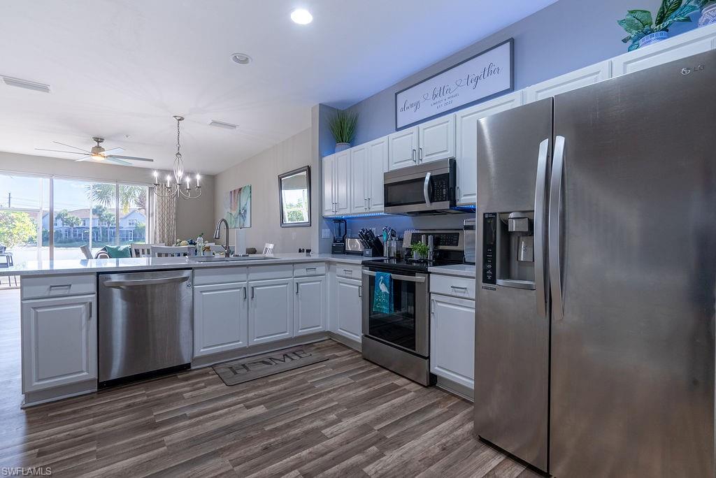 15792 Marcello Circle, Unit 182 Naples, FL 34110 - Photo 12 of 50 a kitchen with granite countertop a refrigerator stove top oven and sink
