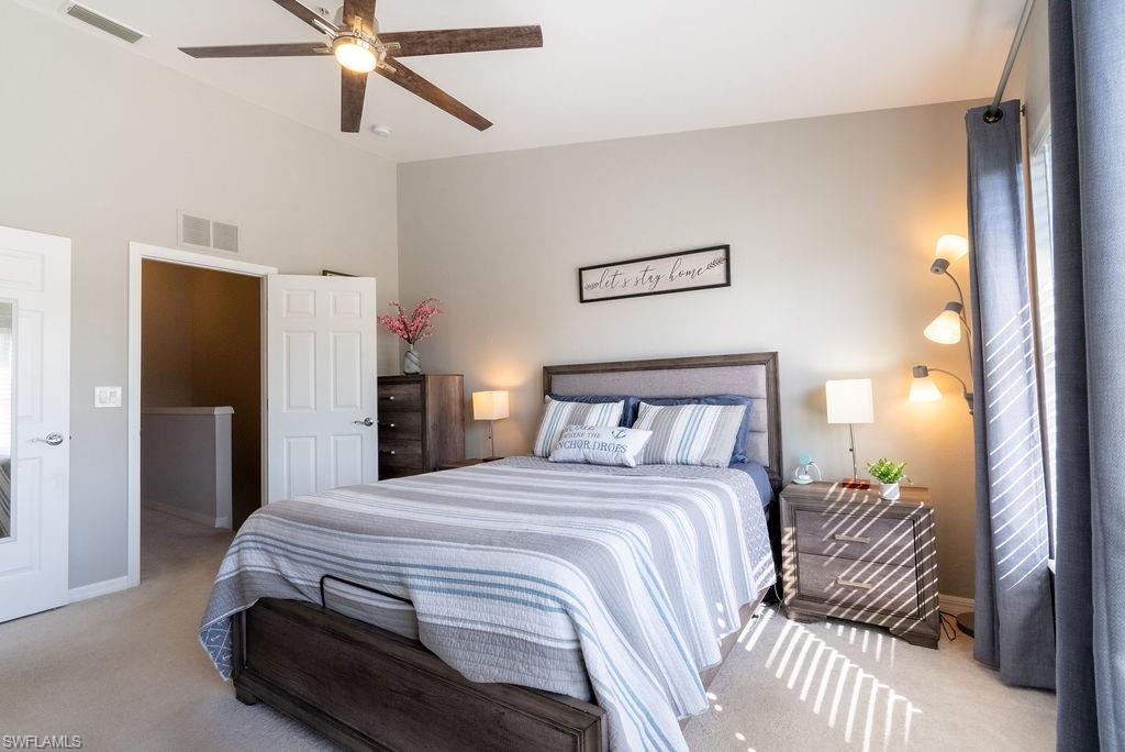 15792 Marcello Circle, Unit 182 Naples, FL 34110 - Photo 28 of 50 a bedroom with a bed and a chandelier