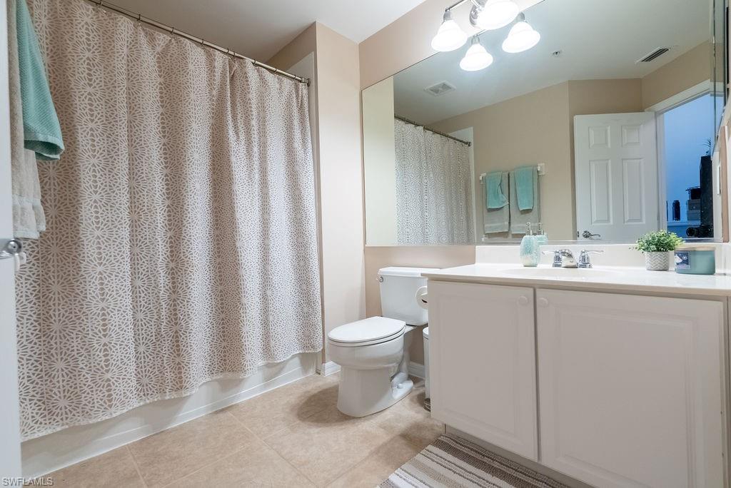 15792 Marcello Circle, Unit 182 Naples, FL 34110 - Photo 38 of 50 a bathroom with a sink a toilet and shower curtain