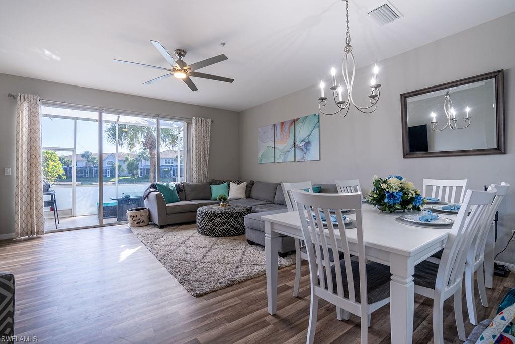 15792 Marcello Circle, Unit 182 Naples, FL 34110 - Photo 7 of 50 a living room with furniture a chandelier and a large window