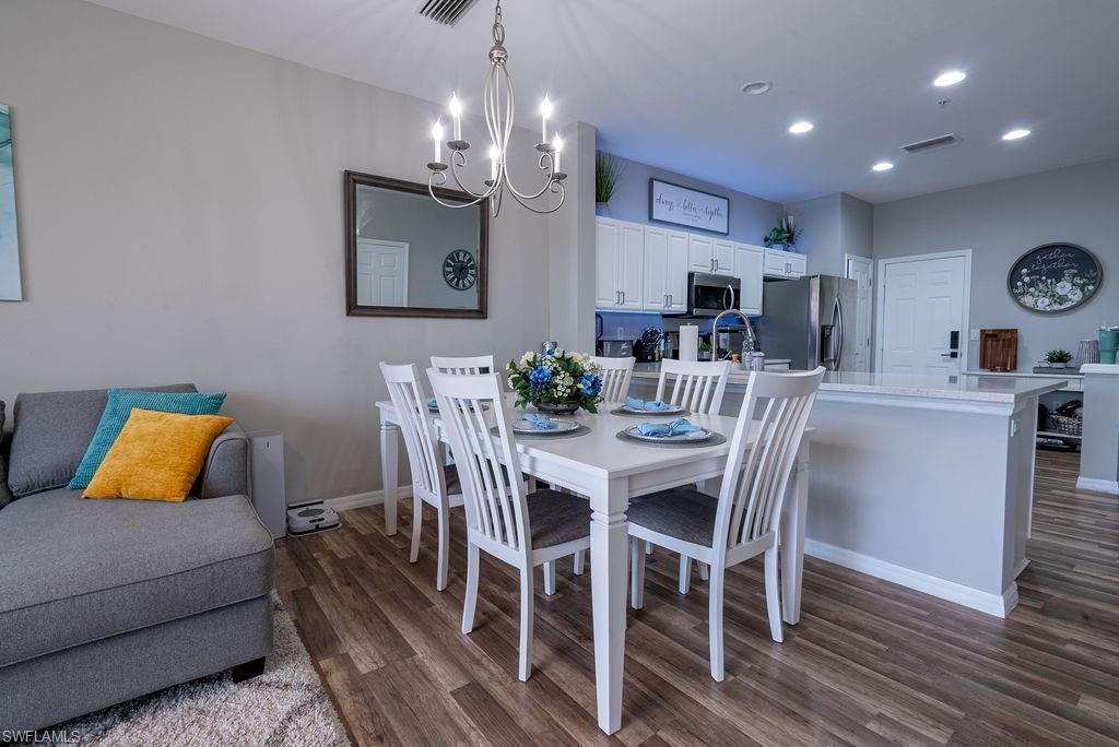 15792 Marcello Circle, Unit 182 Naples, FL 34110 - Photo 9 of 50 a view of a dining room with furniture and wooden floor