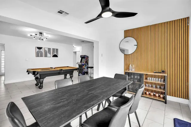 a dining room with wooden floor a chandelier a wooden table and chairs
