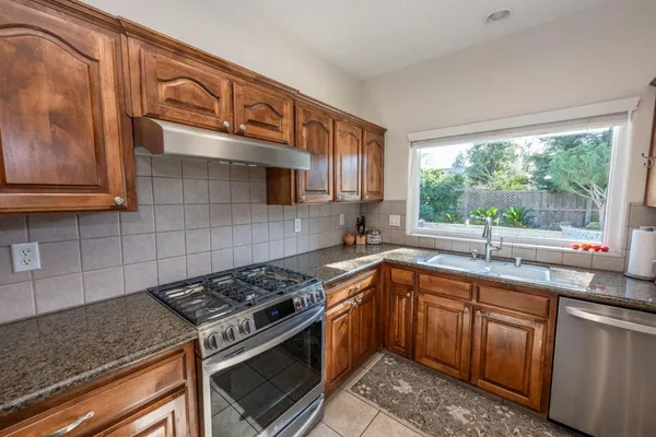 a kitchen with a sink stove top oven and cabinets