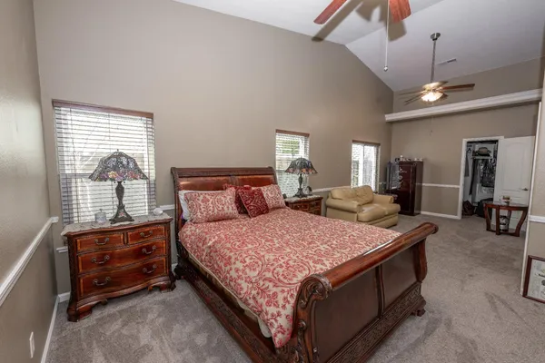a bedroom with a bed a chandelier and dresser