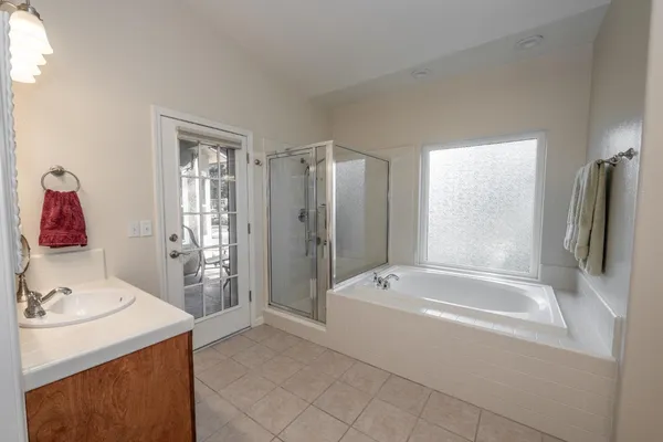 a bathroom with a tub sink and mirror