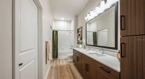 a bathroom with a double vanity sink a mirror and a shower