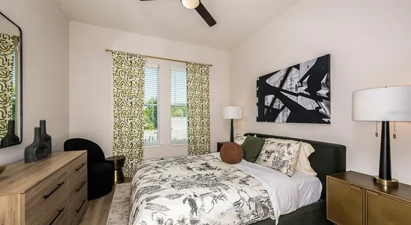a bedroom with a bed and a dresser next to a window