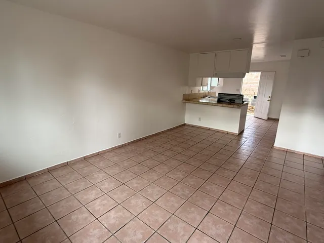 a view of empty room with kitchen