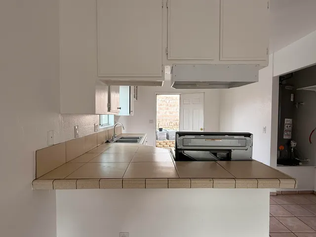 a kitchen with kitchen island white cabinets and stainless steel appliances