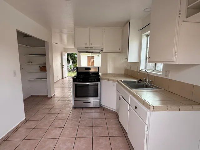 a kitchen with a sink a stove and cabinets