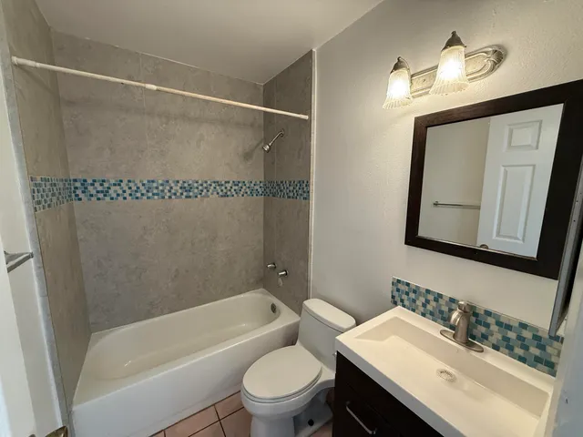a bathroom with a sink mirror toilet and bathtub