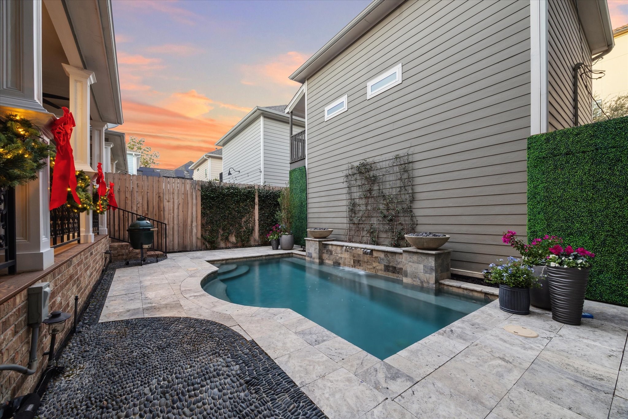 606 Rutland Street Houston, TX 77007 - Photo 45 of 48 The cozy backyard with a small, modern pool surrounded by a stone patio. The area is accentuated with planters and a privacy fence, offering a serene outdoor retreat.