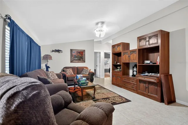 a living room with furniture a flat screen tv and kitchen view