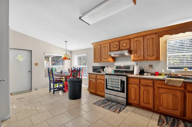 a kitchen with stainless steel appliances granite countertop a refrigerator a stove and a sink