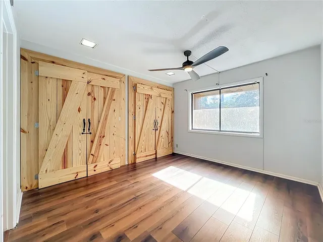 a view of a house with a small yard and a large tree