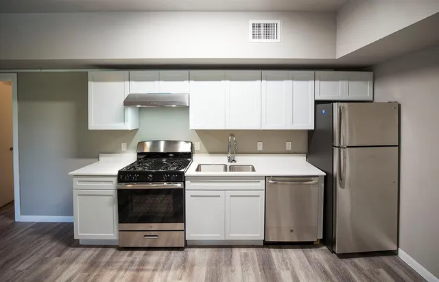 a kitchen with a stove top oven and refrigerator