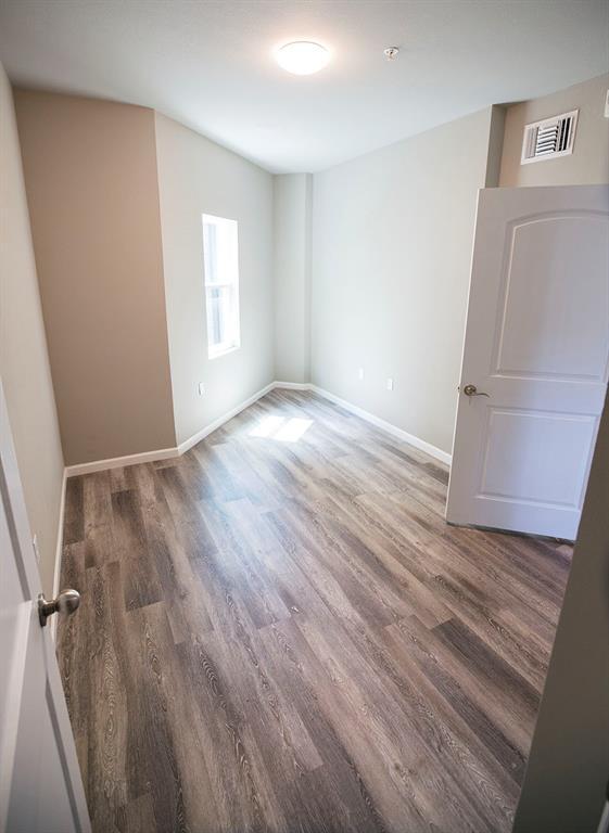 911 West 22nd Street, Unit 303 Austin, TX 78705 - Photo 22 of 23 an empty room with wooden floor and windows