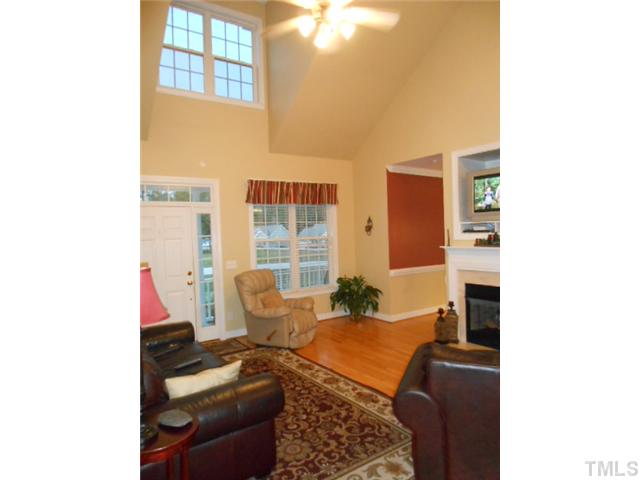 228 Sandstone Road Henderson, NC 27537 - Photo 2 of 25 Family room with vaulted ceiling and gas log fireplace separating family room and dining room. Beautiful hardwood floors.
