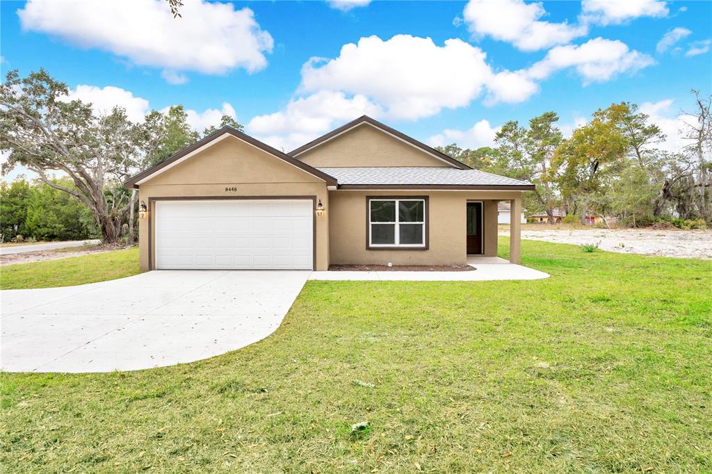 a view of a house with a yard and garage