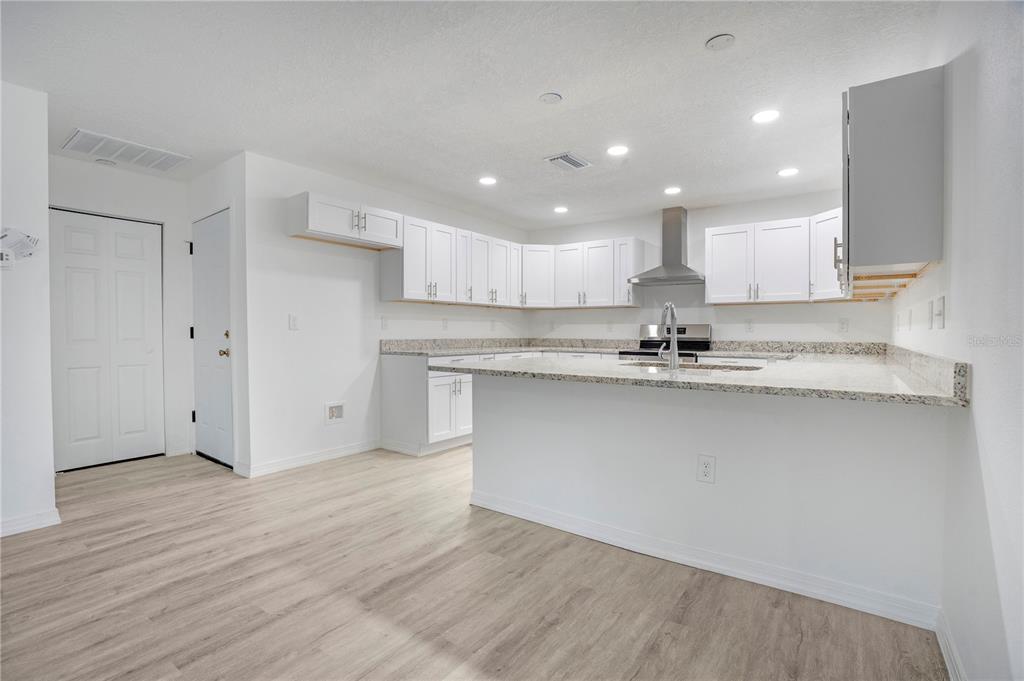 8448 Balm Street Weeki Wachee, FL 34607 - Photo 18 of 44 a kitchen with granite countertop a sink and cabinets