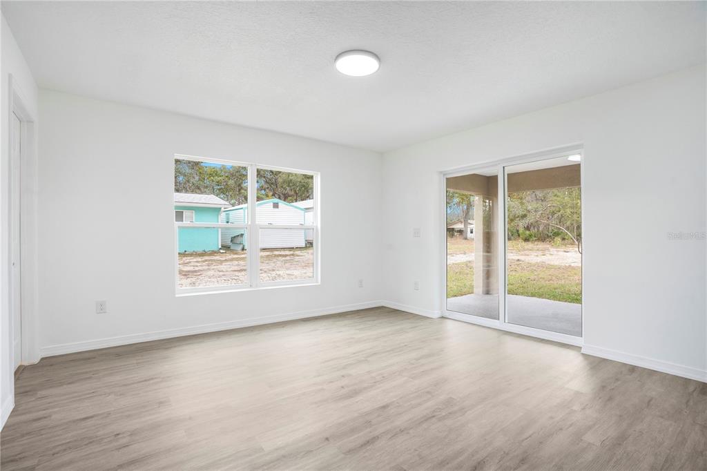 8448 Balm Street Weeki Wachee, FL 34607 - Photo 20 of 44 an empty room with wooden floor and windows