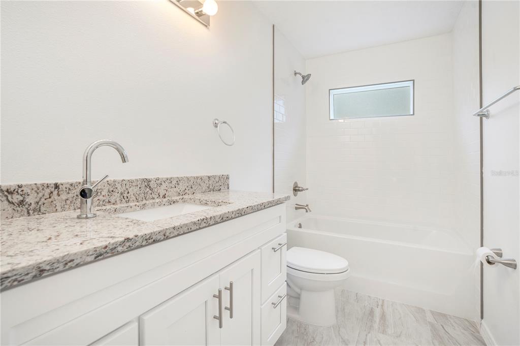 8448 Balm Street Weeki Wachee, FL 34607 - Photo 23 of 44 a bathroom with a granite countertop sink toilet and shower