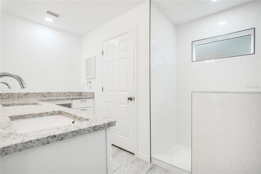 8448 Balm Street Weeki Wachee, FL 34607 - Photo 24 of 44 a bathroom with a granite countertop sink and a mirror